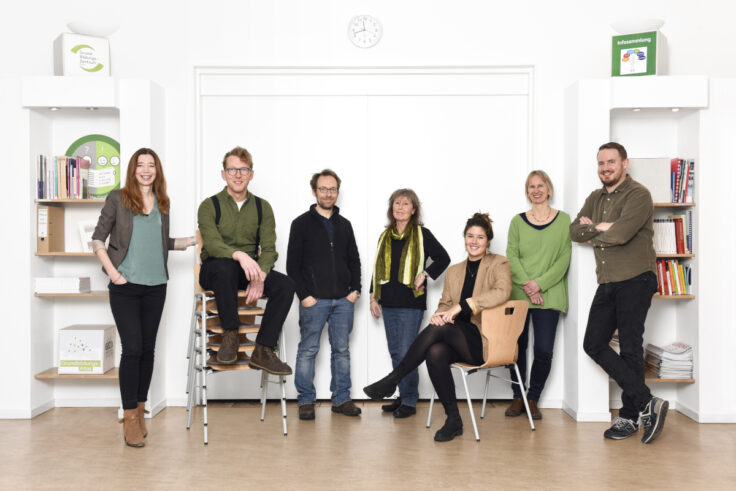 Ein Presse-Foto, das das Team des Grund-Bildungs-Zentrums Berlin stehend in einem Schulungsraum zeigt.